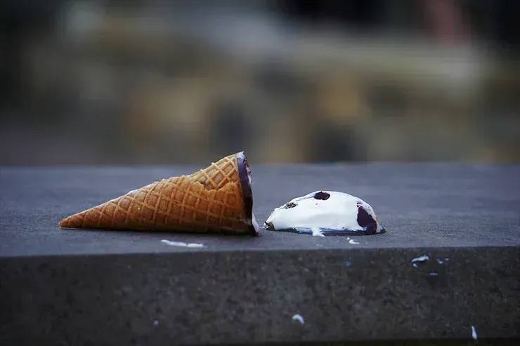 A broken ice cream cone resting on a table.
