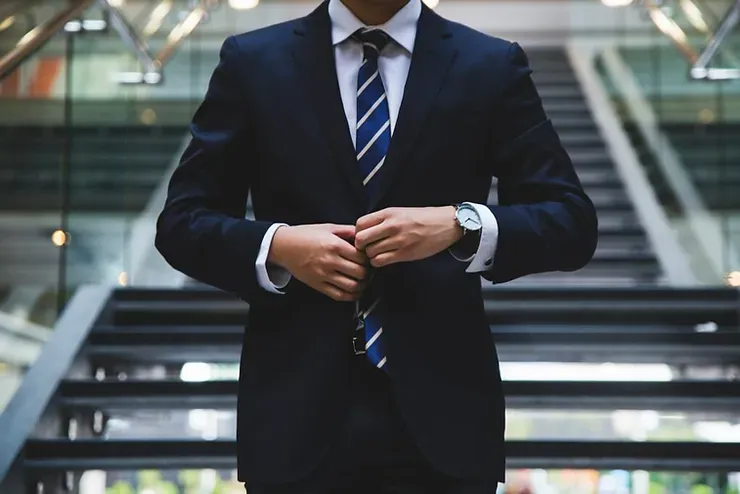 A man in a suit standing on a flight of stairs.