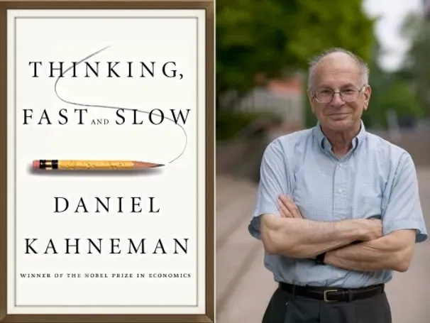 A man standing next to a book titled thinking fast and slow