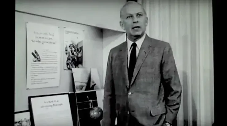 A black and white photo of Bill Bernbach in a suit and tie